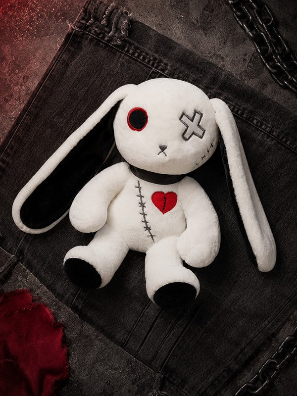 Flat-lay of Reborn Rabbit Doll gothic plush with floppy ears, stitched body and red heart on black fabric