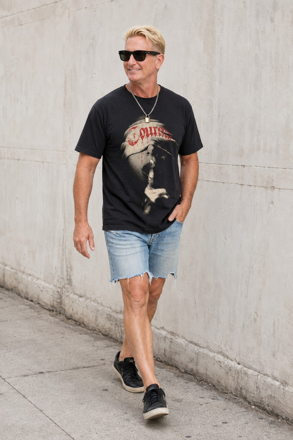 Man walking in the black Courage graphic T-shirt with denim shorts