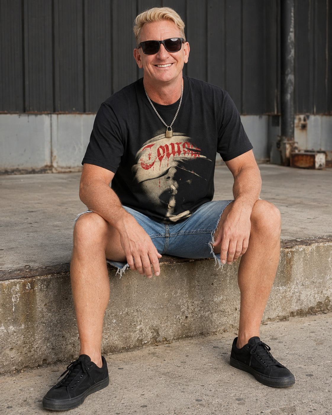Man seated wearing the black Courage graphic streetwear T-shirt