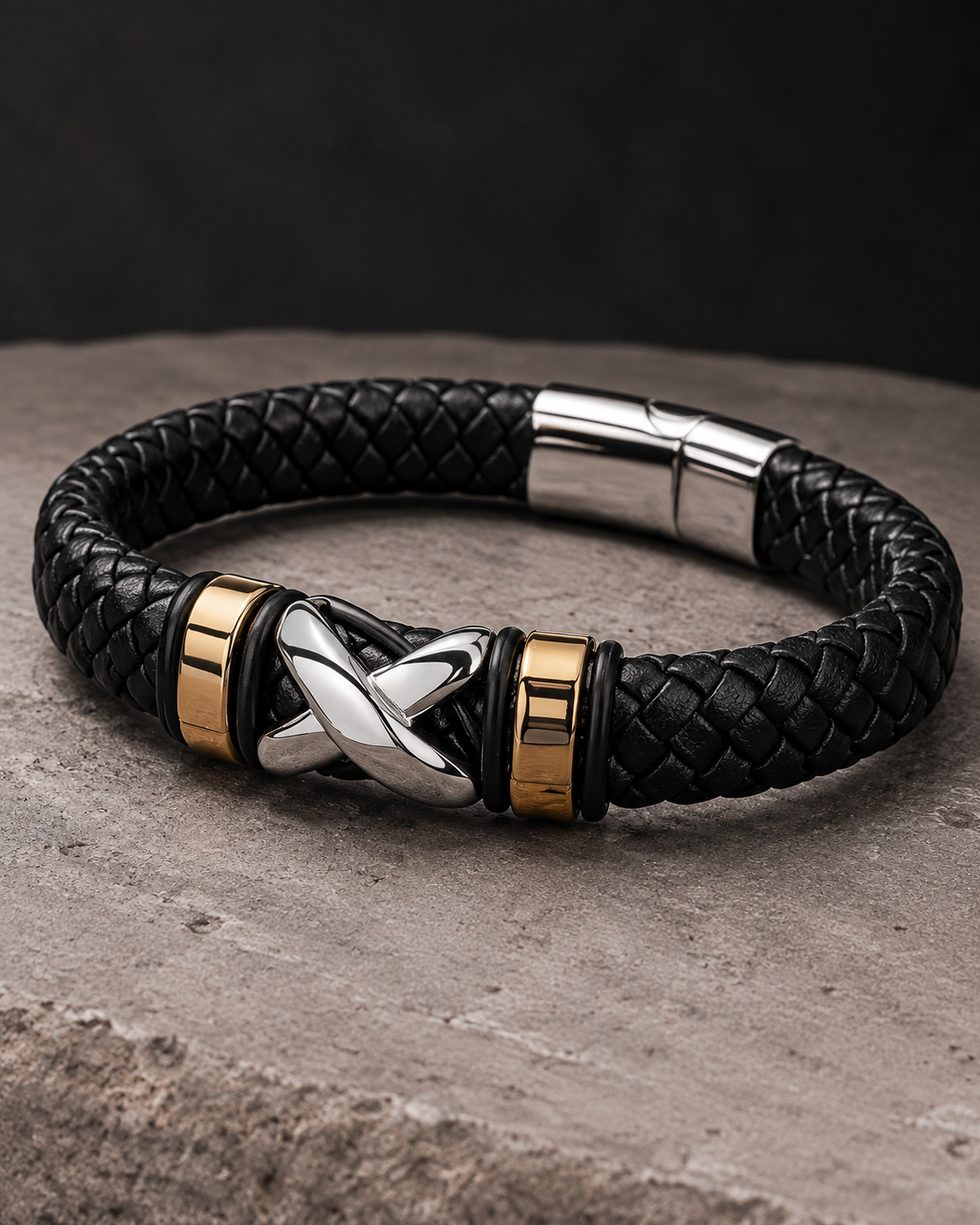 Close-up of silver criss cross knot and gold accents on black leather bracelet