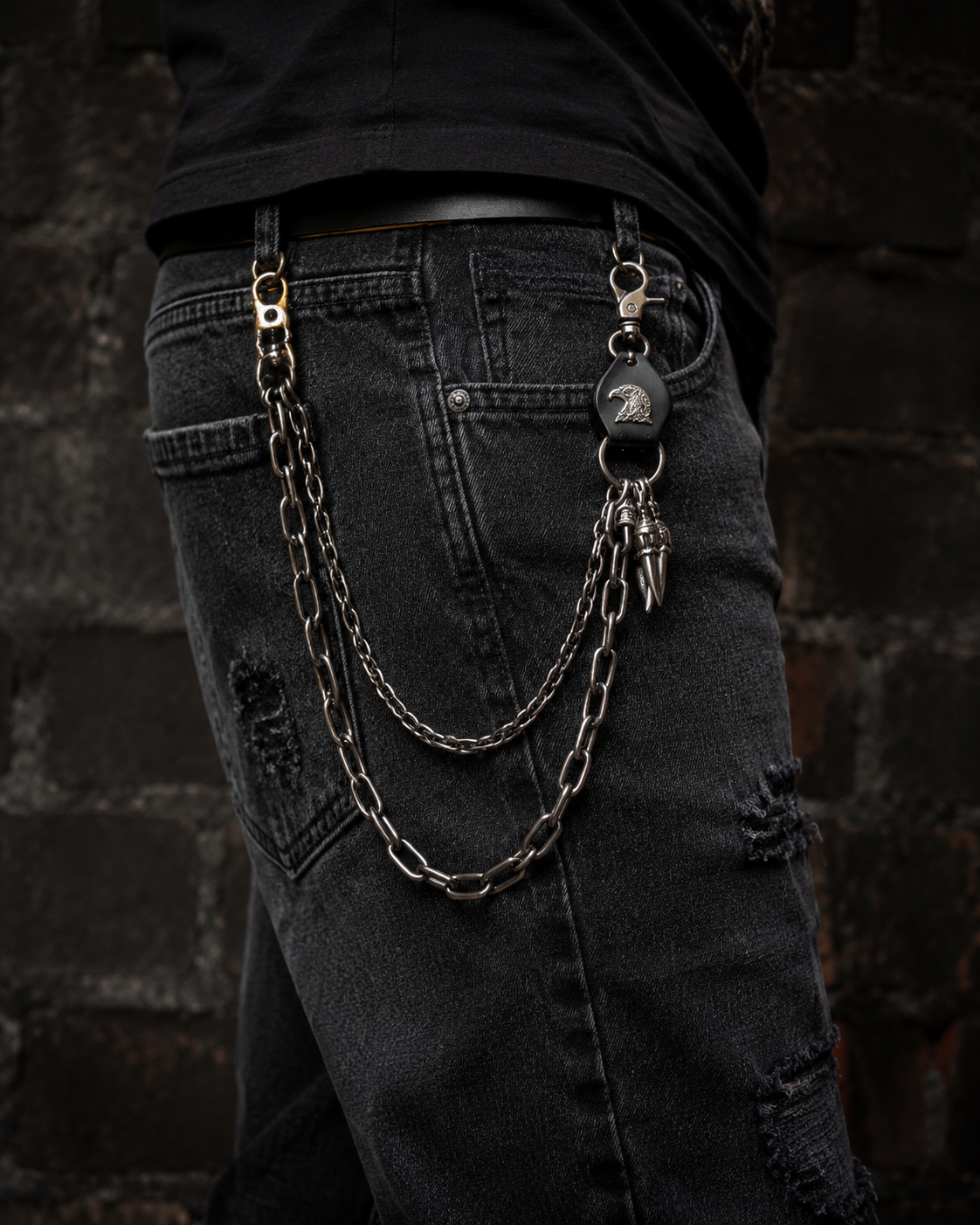 Close-up of the Eagle Waist Chain clipped to black ripped jeans at the hip
