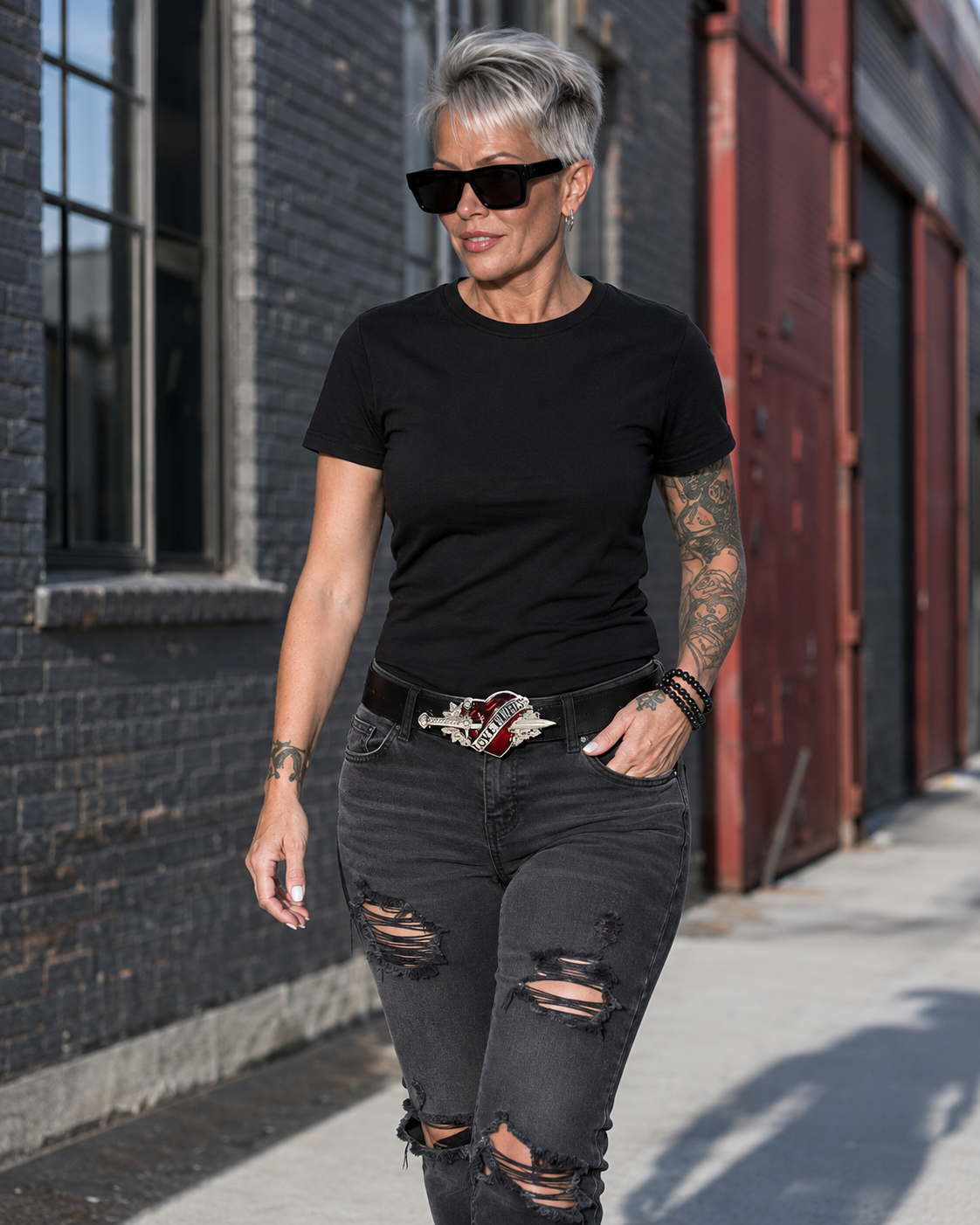 Blonde woman walking in black jeans wearing the Love Hurts statement belt