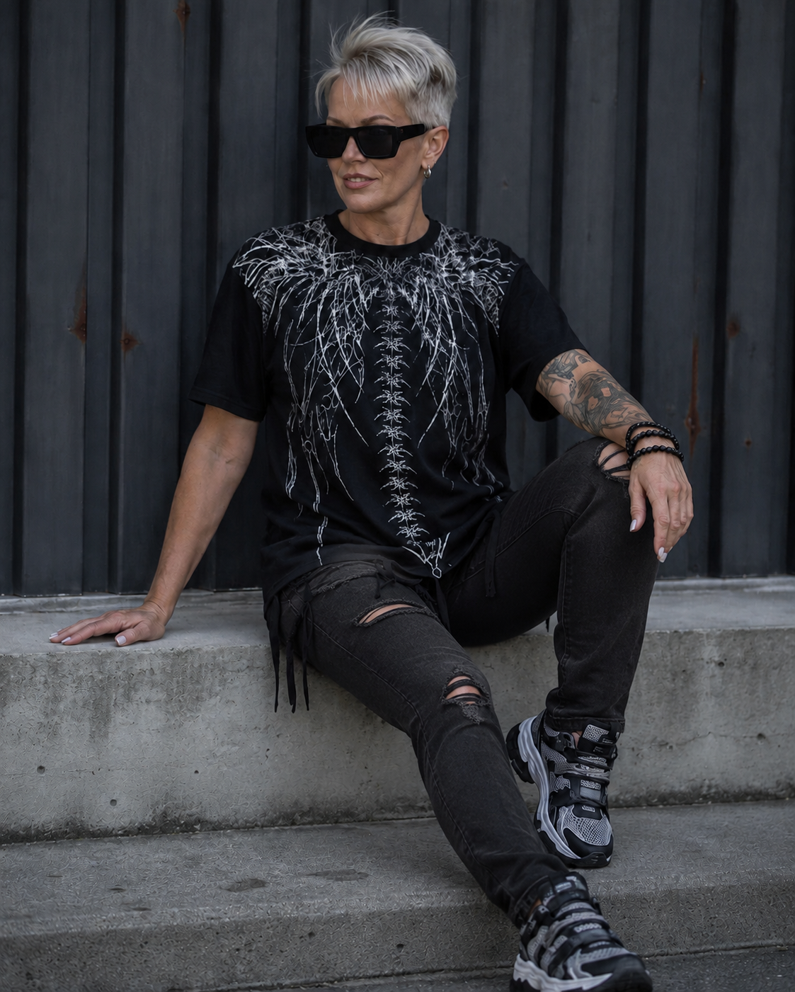 Woman wearing the Spine Graphic Streetwear T-Shirt with black ripped jeans
